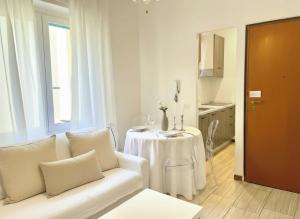 a living room with a white couch and a table at La Nena Appartamenti - Home in the heart of the city center in La Spezia