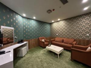 un soggiorno con un divano e un tavolo di Al Jawahiri Hotel a Erbil