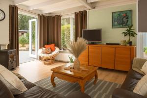 a living room with a couch and a tv at Zenda's natuurhuisje in Lanaken