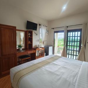 Un dormitorio con una cama, un escritorio y un televisor. en Koh Mook The Home, en Ko Muk