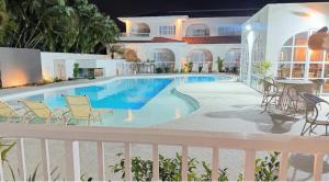 a swimming pool in a building with chairs and a table at Santé Vivre L'Experience in Búzios