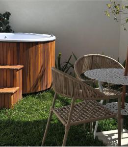 two chairs and a table next to a hot tub at Santé Vivre L'Experience in Búzios