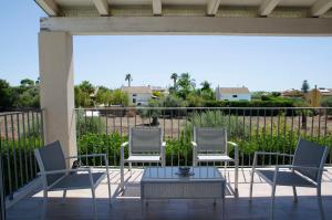 3 Stühle und ein Tisch auf einer Terrasse in der Unterkunft Villa Chiara in Pozzallo