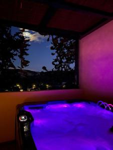 ein lila Zimmer mit einer Badewanne vor einem Fenster in der Unterkunft La parenthèse dorée in Les-Pennes-Mirabeau