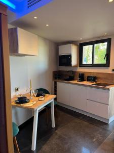 eine Küche mit einem Holztisch in einem Zimmer in der Unterkunft La parenthèse dorée in Les-Pennes-Mirabeau