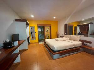 a bedroom with a bed and a tv in it at Leon Oasis Nai Harn in Rawai Beach