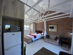 a bedroom with a bed and a brick wall at Quilla Quarters in Plumstead