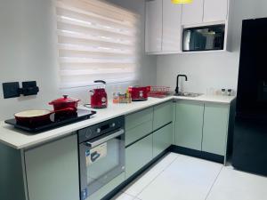 NorthamANG COMSAT Guesthouse的厨房配有白色橱柜和红色家电