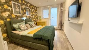 a bedroom with a bed and a flat screen tv at Triple M in Seligenstadt