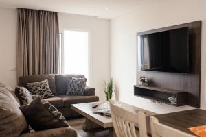 a living room with a couch and a tv at Casa Piquita in Estreito da Calheta