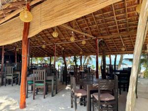 ein Restaurant mit Tischen und Stühlen unter einem Holzdach in der Unterkunft IN Lanka Hotel and Restaurant in Tangalle