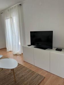 a living room with a flat screen tv on a white cabinet at Lúmina Vir in Vir