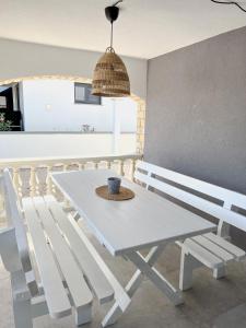 a white table and bench in a room at Lúmina Vir in Vir