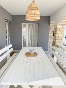 a white dining room with a white table at Lúmina Vir in Vir