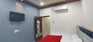 a room with a bed and a tv on the wall at Annapurna Hotel in Ujjain