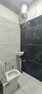 a bathroom with a toilet and a sink and a light at Annapurna Hotel in Ujjain