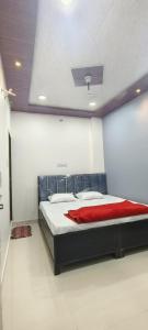 a bedroom with a large bed with a red blanket at Annapurna Hotel in Ujjain
