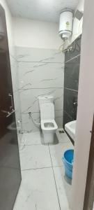 a white bathroom with a toilet and a sink at Annapurna Hotel in Ujjain +8 photos