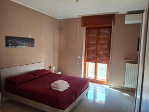 フォッジャにあるB&B Dolce Riposoのベッドルーム1室(赤いシーツ付きのベッド1台、窓付)