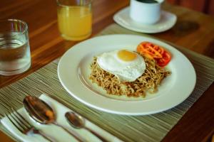a plate of noodles with an egg on top at Waras Villa in Gili Trawangan