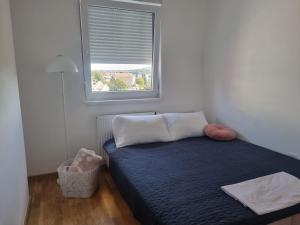 a small bedroom with a bed with a window at Apartman Milica in Doboj