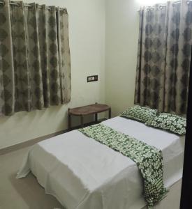 a bedroom with two beds and a window with curtains at Chillout home stay in Ernakulam