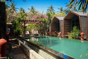 a swimming pool in front of a house at Waras Villa in Gili Trawangan +28 photos