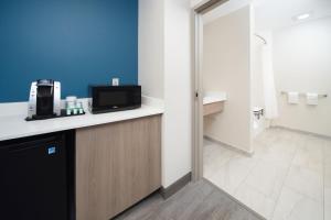 a room with a counter with a microwave on it at Holiday Inn Express & Suites Indianapolis - East by IHG in Indianapolis +48 photos
