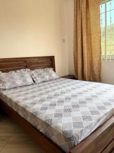 a bedroom with a bed with a checkered bedspread at Private Villa in Bagamoyo in Bagamoyo