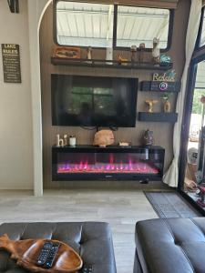 Una sala de estar con chimenea y televisión. en Hurricane Hideaway, en Farmerville
