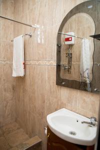 a bathroom with a sink and a mirror at Wanzy Guest House in Kumasi