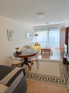 シュトゥットガルトにあるStudio Apartmentのリビングルーム(テーブル、黄色のソファ付) +8枚の写真