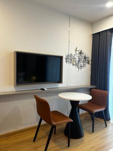 une pièce avec une table et deux chaises et une télévision dans l'établissement Wyndham Lynn Times Thanh Thuỷ - Căn hộ khách sạn Onsen 5 sao, à La Phu