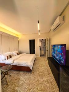 a bedroom with a large bed and a flat screen tv at مهند هوم 24 in Al Khobar