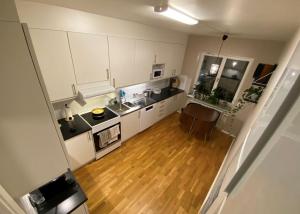 a kitchen with white cabinets and a wooden floor at City apartment with balcony in Norrköping