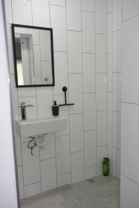 a white tiled bathroom with a sink and a mirror at Nirvana Cottage in Cape Town +17 photos