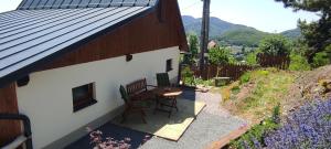 Un pequeño patio con una mesa y sillas al lado de un edificio. en Pod farárovou hôrkou, en Banská Štiavnica