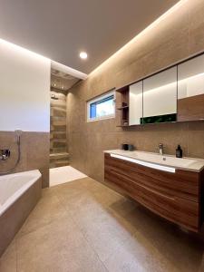 YspertalにあるLodge am Wasserのバスルーム(バスタブ、シンク、バスタブ、バスタブ付) +22枚の写真