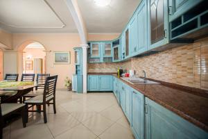 a kitchen with blue cabinets and a table with chairs at Vila Rroshaj in Tirana