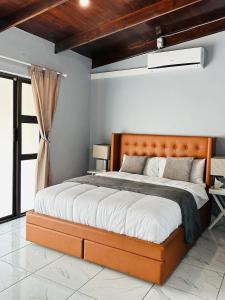 Un dormitorio con una cama grande con cabecero de madera. en Major's Villè, en Swakopmund