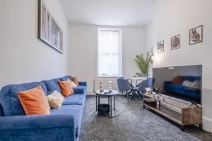 a living room with a blue couch and a table at Contractors! Free parking, Wifi, 6 BDR, 10 Beds! in Elswick