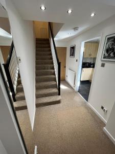 eine Treppe in einem Haus mit weißen Wänden und Teppich in der Unterkunft Cosy Contractor House with Garden & Parking! in Yeovil
