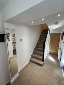 ein Flur mit einer Treppe in einem Haus in der Unterkunft Cosy Contractor House with Garden & Parking! in Yeovil + 9 Fotos