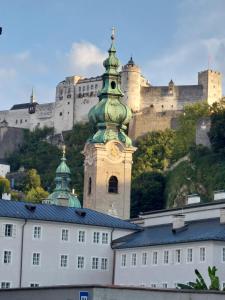 a building with a clock tower in front of a castle at Appartement Wintergarten in Seenähe in Perwang