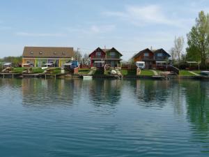 a group of houses next to a body of water at Kis vízparti házikó in Gyékényes