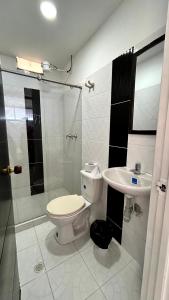 a bathroom with a toilet and a sink at Apartamento Zona Centro in Ibagué +8 photos