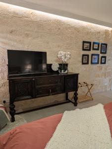 een woonkamer met een flatscreen-tv aan de muur bij Mahogany - Rooftop Views - Close to Valletta Ferry in Senglea +6 foto's