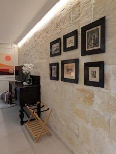 een stenen muur met een tafel en foto's erop bij Mahogany - Rooftop Views - Close to Valletta Ferry in Senglea