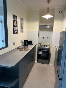 a kitchen with a counter top and a stove at Departamento Nuevo con la comodidad que necesitas in Temuco