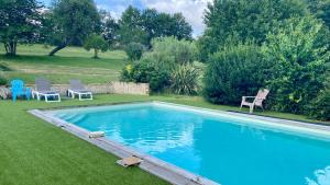 a large swimming pool with two chairs and a table at Les Gîtes de Leymandie in Saint-Avit-de-Vialard